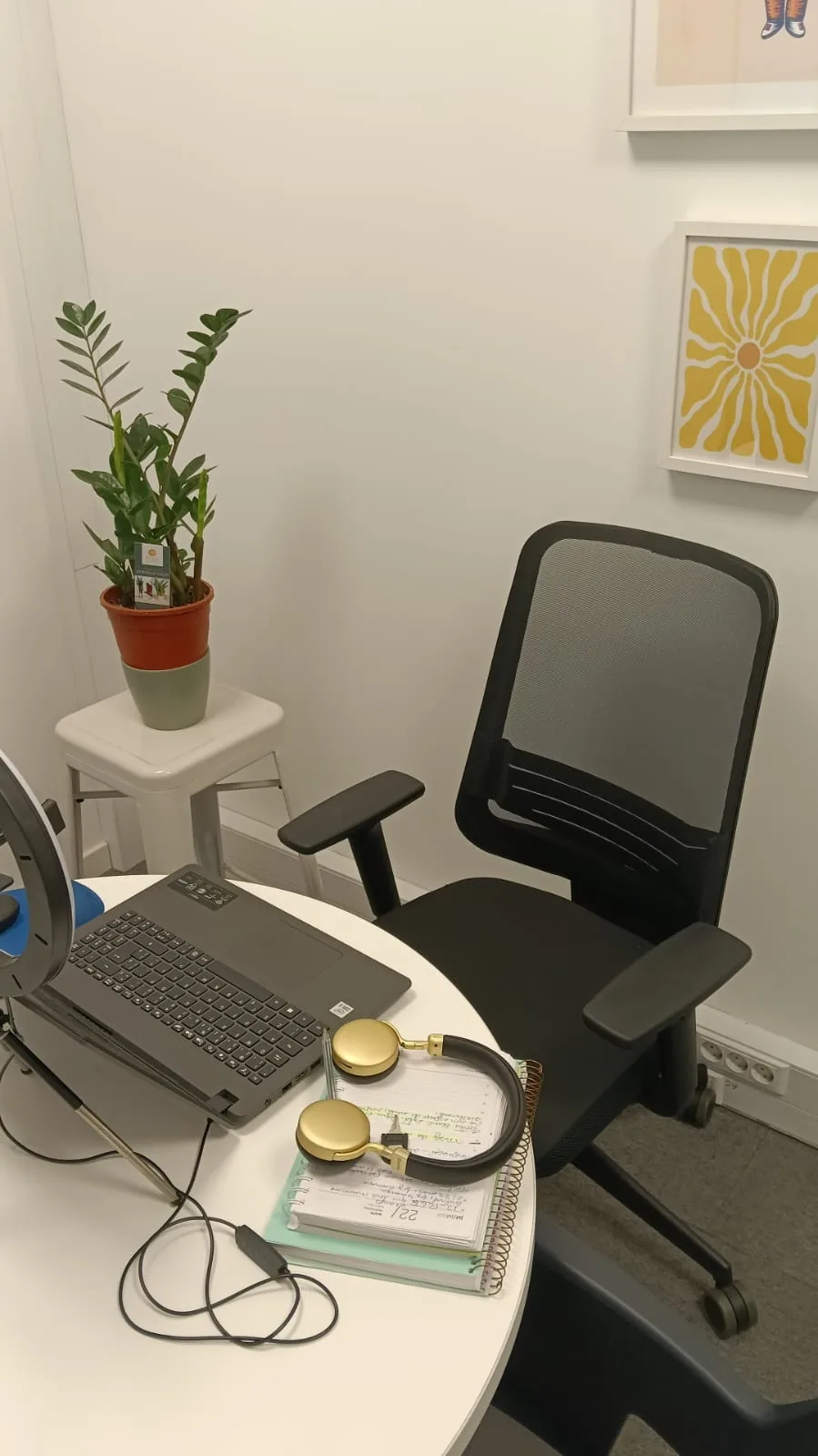 Mesa de atendimento online com notebook, caderno de anotações e planta